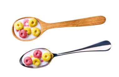 Beyaz arka planda izole edilmiş mısır halkaları ve çilek halkaları. Süt izole edilmiş mısır gevreği kaşığı. Meyve aromalı tahıl. Meyveli gevrek. Renkli mısır halkaları