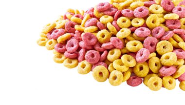 Beyaz arka planda mısır halkaları ve çilek halkaları kahvaltıda sağlıklı tatlı atıştırmalıklar. Mısır gevreği meyveli halkalar renkli halkalar. Renkli mısır halkaları..