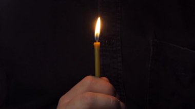 Dindar adam mum alevini üflüyor, günü hatırlıyor, umudun ruhani sembolü..