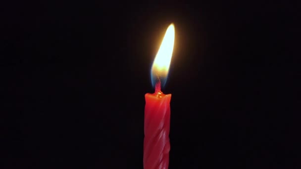 一支红色的大蜡烛亮了又灭 被黑色的背景隔开 慢动作 中央框4K — 图库视频影像
