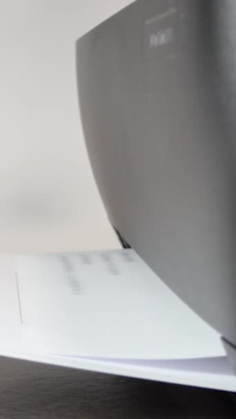 活動中のプリンター 印刷されている紙シート オフィス環境で文書を印刷する黒のプリンター機の詳細ショット — ストック動画