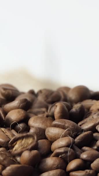 焙煎コーヒー豆が落ちる 香り高いコーヒー豆がローストされていますスローモーション 回転カメラ 有機コーヒーの種 — ストック動画