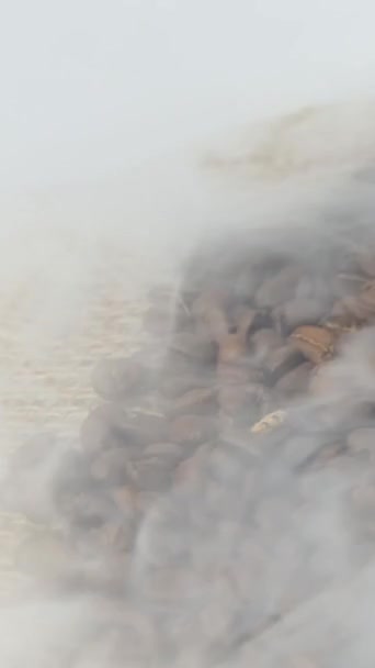 烤咖啡豆的特写 香味咖啡豆是咖啡豆烘烤出来的烟 油炸谷物放在一个褐色的袋子上 慢动作旋转相机 — 图库视频影像