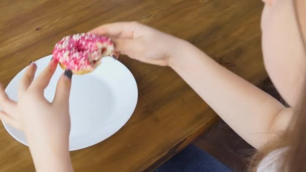 ブロンド女性一つと別のドーナツをかむと甘い味を楽しむ — ストック動画