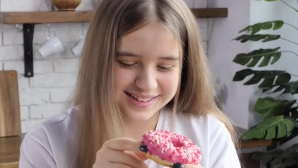 カラフルなアイシングと笑顔でドーナツを食べる女性のクローズアップ — ストック動画