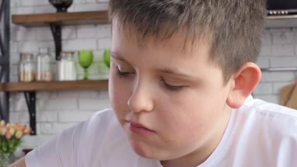 身穿白色T恤的饥肠辘辘的年轻人一边吃薯条 一边闭着眼睛在厨房里品尝着它的味道 — 图库视频影像