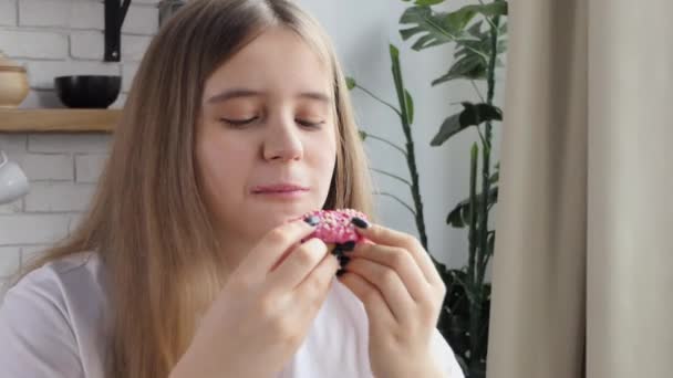 摂食障害の少女はすぐにドーナツを食べる 女子高生は貪欲にドーナツを食べる 甘い中毒と食べ過ぎの概念 — ストック動画