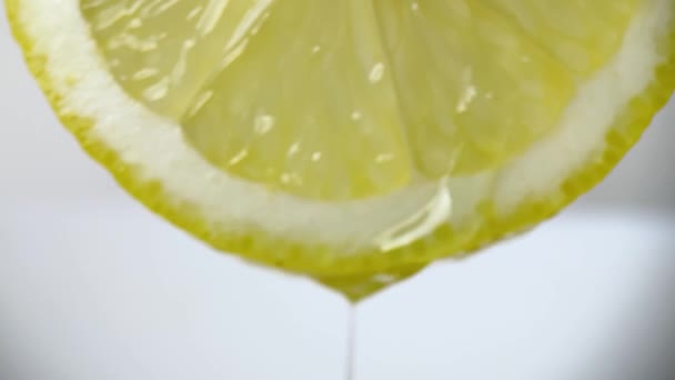 白い背景にレモンのスライスの半分に水が注ぐ — ストック動画