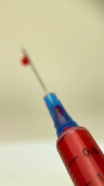 Kan alan bir şırıngayı kapat. Şırıngaya kan çekmek. Şırınga ve kan.