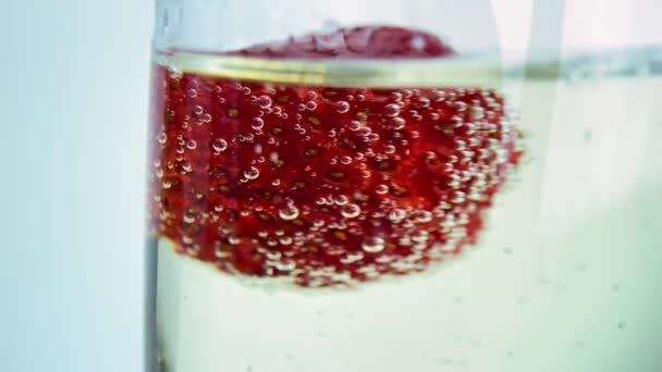 一个女人的手把冰冻的草莓放进香槟里 葡萄酒开始起泡 — 图库视频影像