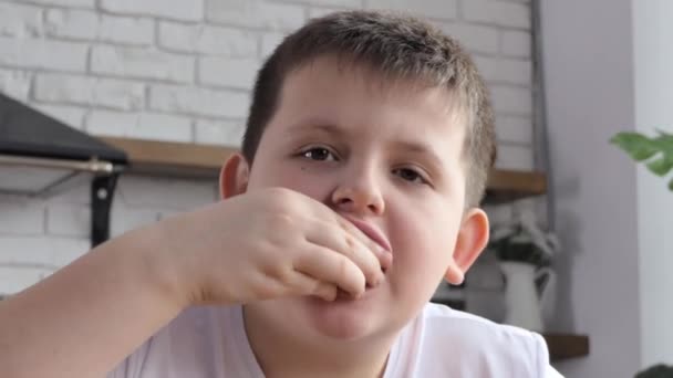 一个穿着白色T恤的男人坐在快餐店的桌子边吃饭 男孩吃薯条 用酱汁浸泡土豆 把食物放进嘴里咀嚼4K — 图库视频影像