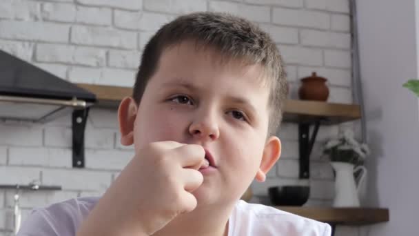 那孩子在厨房里吃薯条 可爱的小男孩一边舔手指 一边吃薯条 蜂蜜宝宝吃快餐 小男孩喜欢吃油炸土豆 — 图库视频影像