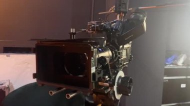 Zoom lensli profesyonel kamera, bir sürü düğme ve anahtar haber stüdyosundaki tripodun üzerinde duruyor. Yayın ya da medya üretimi için yer değiştirme ekipmanlı TV kamerası.