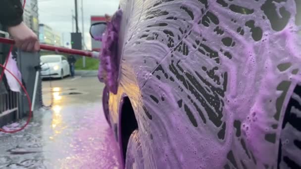 車の洗面で車の表面石鹸ブラシラブヘッドライトを乾燥汚れを洗います 活性発泡体は 体から汚れを削除します 車の世話だ 手動洗車 — ストック動画