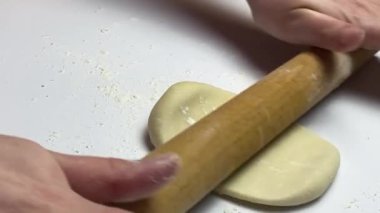 Kadınların elleri hamurun içinde kutba veya chebureki, kıyma ve soğan pişirirken