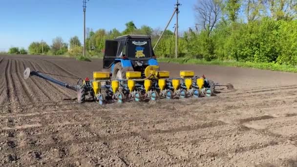 Sebuah Traktor Dengan Seeder Naik Melalui Lahan Dibajak Dengan Penanam — Stok Video