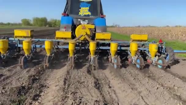 種子を持つトラクターは プランターで耕されたフィールドを通って春に小麦を播種します 春に穀物を播種する農業ビジネス ウクライナの農民のための春の播種キャンペーン — ストック動画
