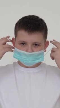 Koronavirüs salgını sırasında bir çocuk maske takıyor. Ağır çekimde yakın çekim. 4K