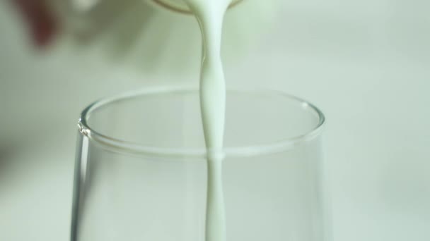慢动作地把牛奶倒在木制桌子上的玻璃杯里 早上吃健康的早餐 谷物和牛奶4K — 图库视频影像