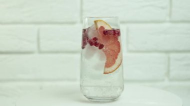 Taze yaz kokteyli yapıyorum. Buzlu bardağa karbonatlı su dökmek. Ağır çekim. limon ve limon dilimleri. Nane, ferahlatıcı soda tonik. Soğuk mojito limonata, köpüklü soda.,