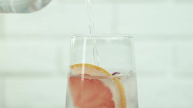 Parlak Bardakta Doğal Meyveli Limon İçeceği. Taze Alkol Kokteyli ya da Ekşi Vejetaryen Parti Limonatası. Fizzy Maden Suyu ve Akan Gaz ve Citron Sağlıklı İçecek Olarak