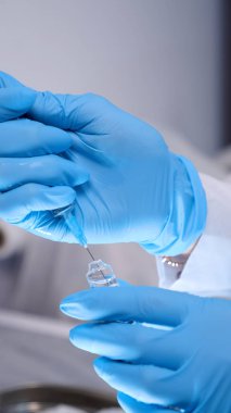 Doktor ya da hemşire cerrahi ameliyata hazırlanıyor ve sağlık kliniğinde ya da hastane ofisinde eldiven takıyor. Sosyal uzaklık, koronavirüs için karantina