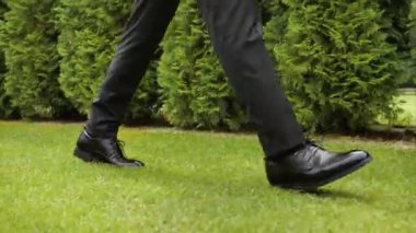 Adamın ayak izleri çimlere basıyor.