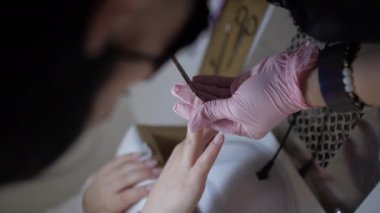 Kadın dosyalama çivi çivi dosya sırasında evde manikür ile kapatın. Genç kadın Evde Manikür yapıyor. Tırnak bakım ve evde manikür kavramı