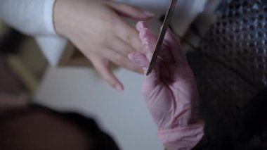 Kadın dosyalama çivi çivi dosya sırasında evde manikür ile kapatın. Genç kadın Evde Manikür yapıyor. Tırnak bakım ve evde manikür kavramı
