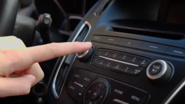 Şoför arabadaki radyoyu ayarlar.