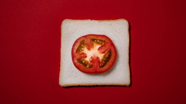 Kırmızı arkaplanda domatesli tost.