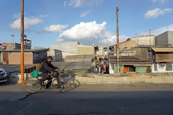 Yetişkin bir adam işten sonra setin oradaki yolda bisiklet sürüyor. Jakarta, Endonezya - 19 Kasım 2022.