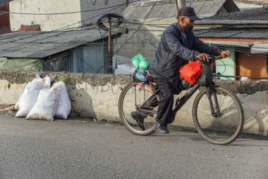 Jakarta, Endonezya - 1 Nisan 2023: Cakarta, Jakarta, Endonezya, Endonezya 'da bisikletle işten eve dönen yaşlı bir adam.