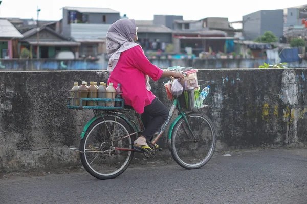 Jakarta, Endonezya - 1 Nisan 2023: Bisikletle gezen bitkisel ilaç satıcısı.