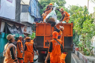 Jakarta, Endonezya - 21 Mayıs 2023: Kamu Altyapı ve Tesisleri İşçileri (PPSU) veya daha çok bilinen adıyla Pasukan Oranye çöpleri temizlemek için birlikte çalışıyor.
