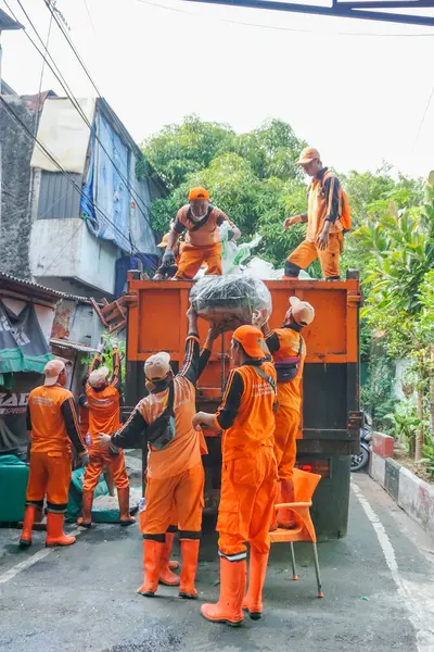 Jakarta, Endonezya - 21 Mayıs 2023: Kamu Altyapı ve Tesisleri İşçileri (PPSU) veya daha çok bilinen adıyla Pasukan Oranye çöpleri temizlemek için birlikte çalışıyor.