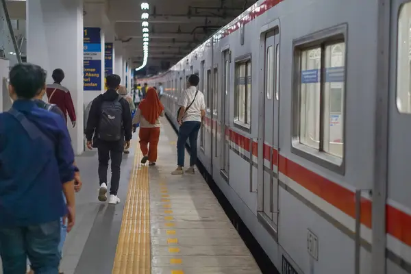 Jakarta, Endonezya - 14 Nisan 2024: Geceleyin Manggarai tren istasyonu Jakarta 'da yürüyen yolcular.