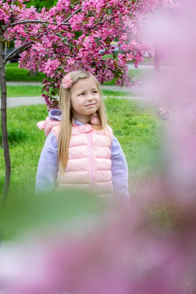 春天花园里穿着粉色连衣裙的漂亮小女孩 — 图库照片