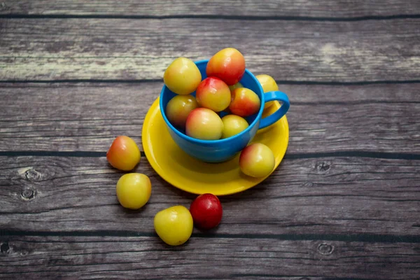Cherry Kuning Manis Dalam Cangkir Kuning Biru — Stok Foto