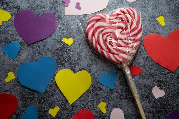 a lollipop lollipop on a stick surrounded by hearts