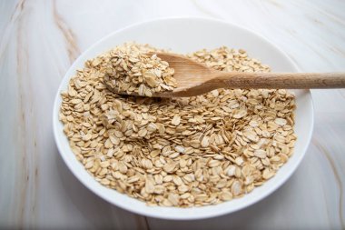 Açık mermer arka planda bir kase yulaf ezmesi.