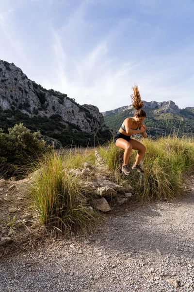 Attractive blonde fitness woman exercising outdoors with lake view.