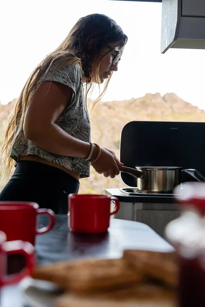 Young woman making breakfast in a motor home. Coffee and toasts