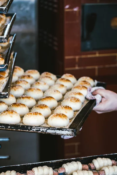 Tanınmayacak halde fırından lezzetli ekmeklerle tepsiyi çıkarıyor. Geleneksel Sicilya mutfağı. 