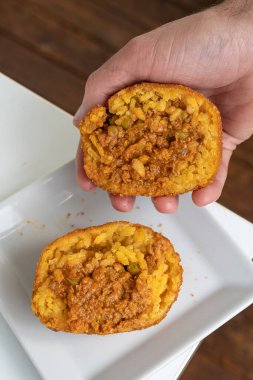 Kızarmış pirinç topu. Arancino Arancina Arancini beyaz bir tabakta ragu ile Sicilya sokak yiyeceği