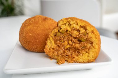 Kızarmış pirinç topu. Arancino Arancina Arancini beyaz bir tabakta ragu ile Sicilya sokak yiyeceği