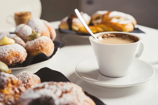 Beyaz bir masada kahve ve kruvasanla kahvaltı. Ön görünüm. 