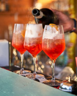 Spritz traditional cocktail with alcohol being prepared by unrecognizable man in a beach bar. European summer drink. Italian drink. Lifestyle concept