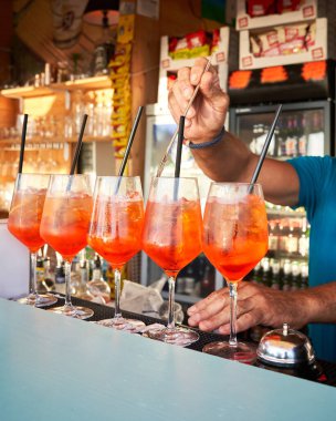 Spritz traditional cocktail with alcohol being prepared by unrecognizable man in a beach bar. European summer drink. Italian drink. Lifestyle concept