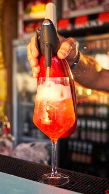 Spritz traditional cocktail with alcohol being prepared by unrecognizable man in a beach bar. European summer drink. Italian drink. Lifestyle concept